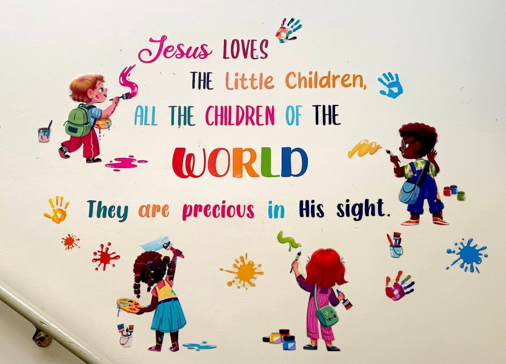 Wall art of children painting the words Jesus loves the little children, all the children of the world, they are precious in His sight